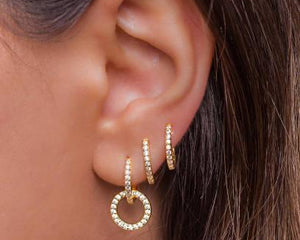Oreilles avec boucles d’oreilles créoles dorées serties de strass, accessoire femme tendance