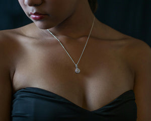 Femme en robe noire avec collier pendentif, bijoux élégants pour soirée, gros plan