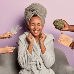 Femme souriante en peignoir de bain et serviette, entourée d’accessoires bien-être spa