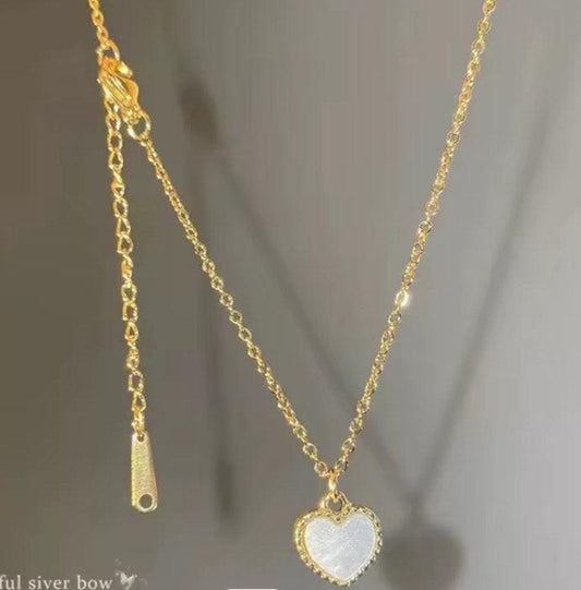 Collier doré chaîne fine avec pendentif cœur blanc pour femme, accessoire élégant.