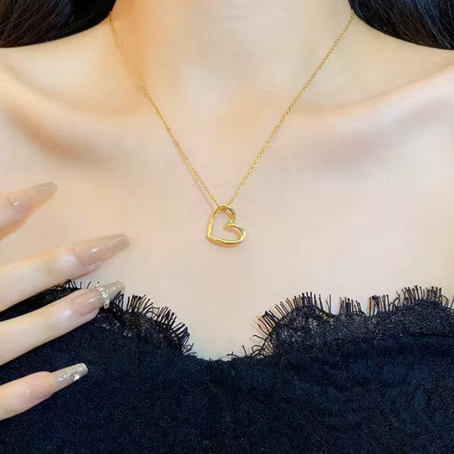 Collier pendentif cœur doré porté avec une robe noire en dentelle, bijou élégant femme