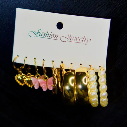 Lot de boucles d’oreilles dorées, perles et ornements rose pour femme, sur fond noir