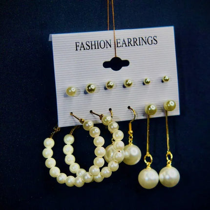 Ensemble de boucles d’oreilles dorées et perles pour femme sur fond bleu élégant.