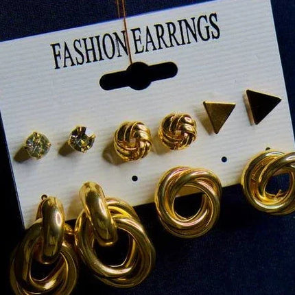 Lot de boucles d’oreilles dorées variées pour femme sur carte présentation.