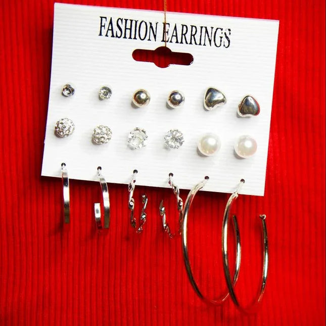 Set de boucles d'oreilles tendance en argenté, perles et strass, sur fond rouge élégant.