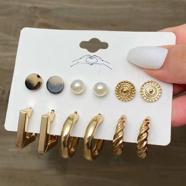 Lot de boucles d’oreilles dorées et perles élégantes sur carte pour femme