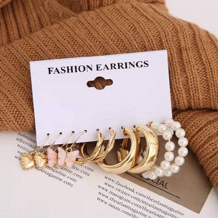 Lot de boucles d’oreilles fantaisie dorées et perles, présentation élégante sur fond beige