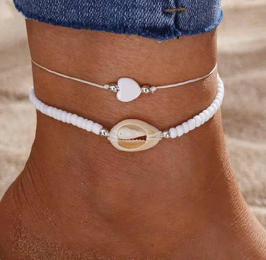 Cheville ornée de bracelets d’été, perles blanches et coquillage, bijou plage tendance femme.