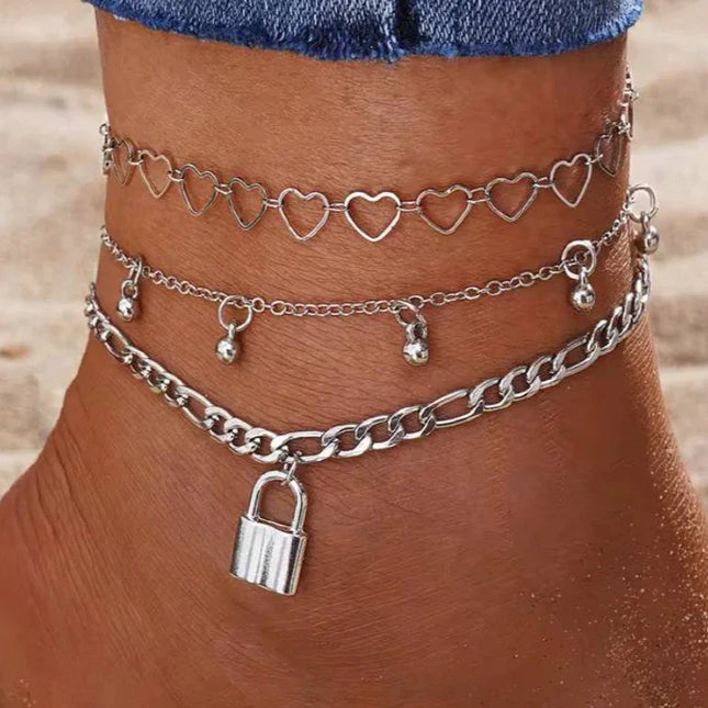 Cheville avec bracelets argentés, motifs cœurs, pampilles et cadenas, mode plage femme